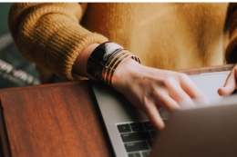 Hands typing on laptop